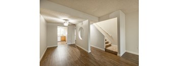an empty living room with hard wood floors and a staircase