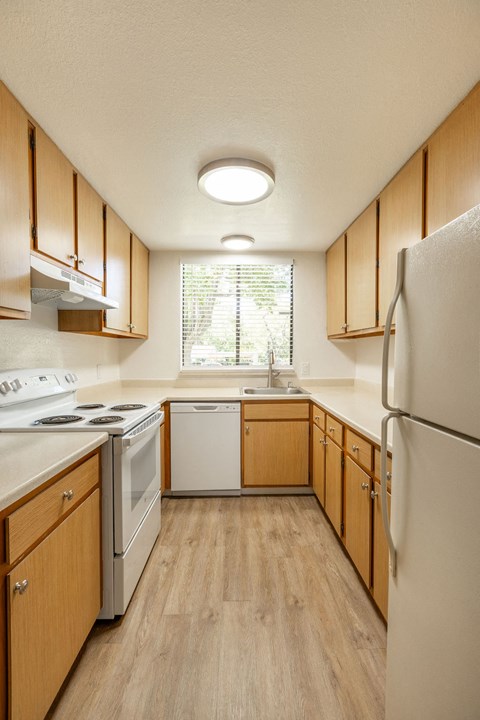 A kitchen with wooden cabinets and white appliances.