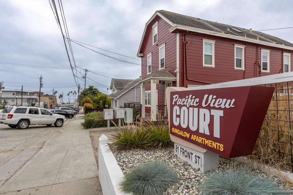 a sign for the public view court in front of a red house