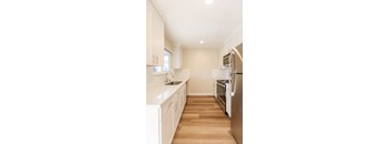 A kitchen with white cabinets and stainless steel appliances.