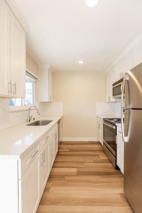 A kitchen with white cabinets and stainless steel appliances.