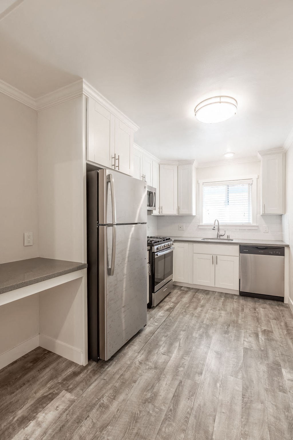 A kitchen with a refrigerator, stove, and oven.