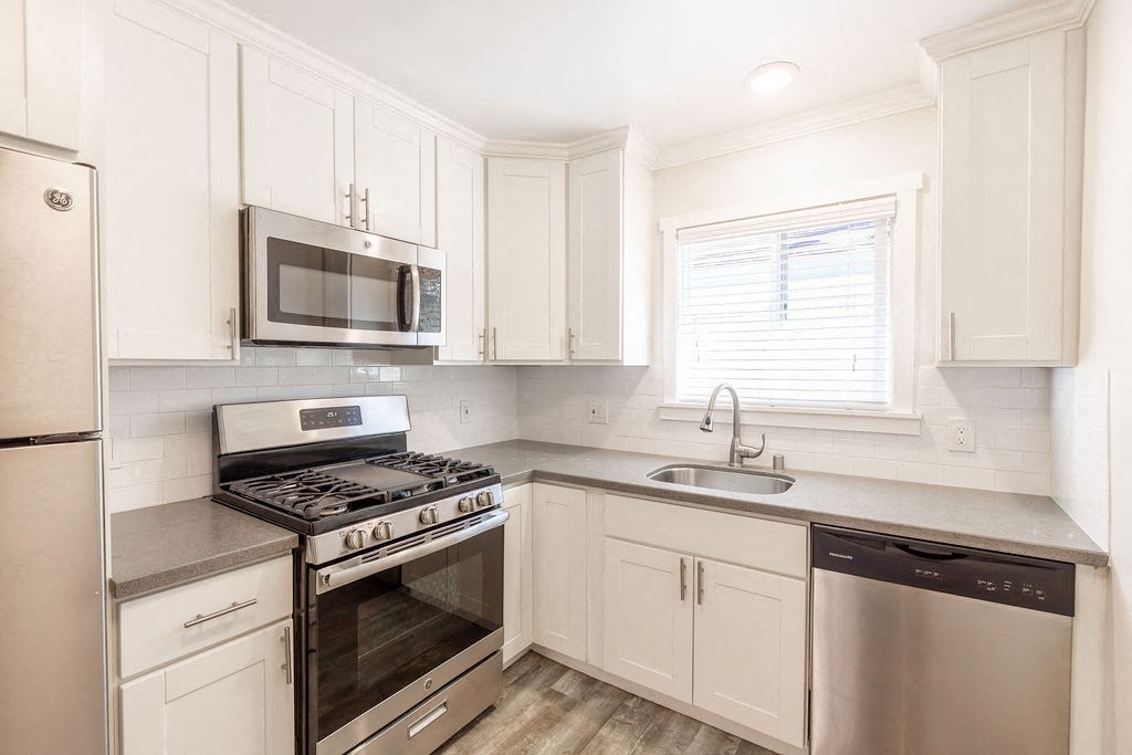 A kitchen with white cabinets and stainless steel appliances.