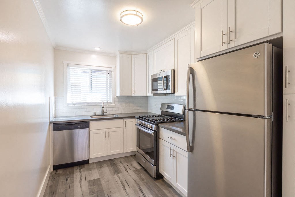 A modern kitchen with a stainless steel refrigerator, oven, and microwave.