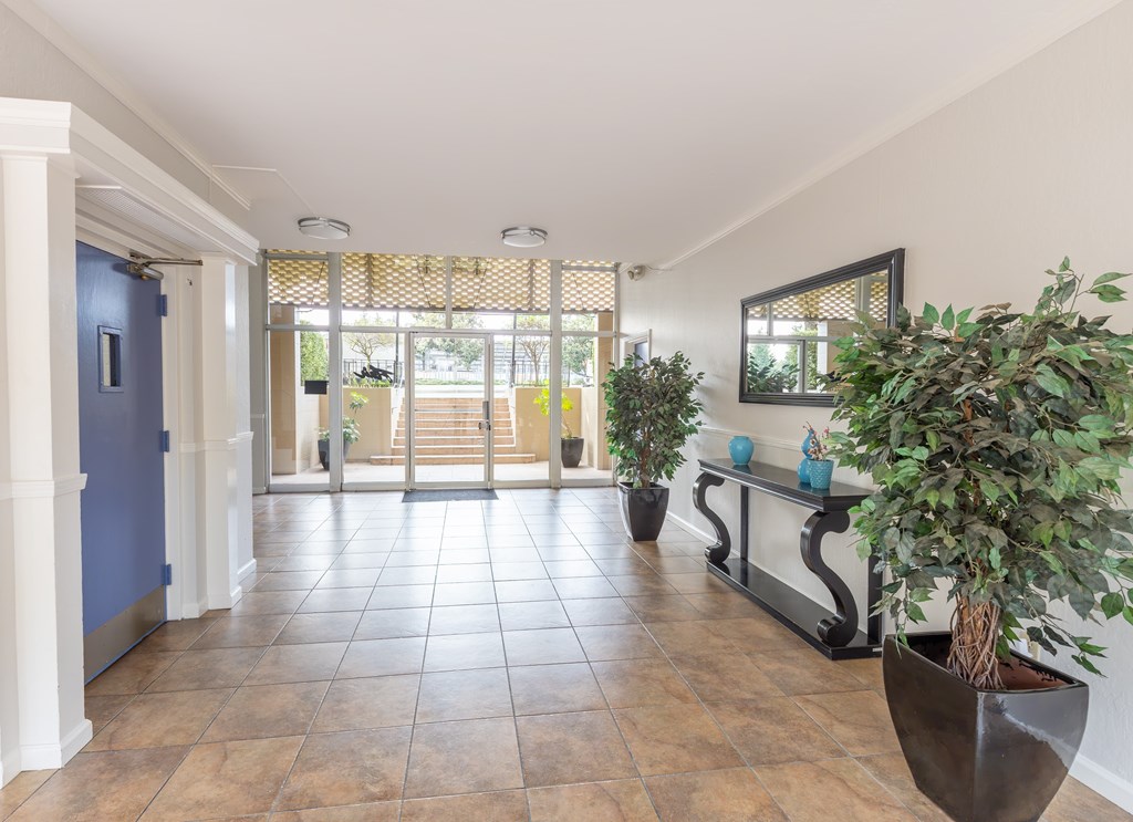A hallway with a blue door and a bench with plants on it.