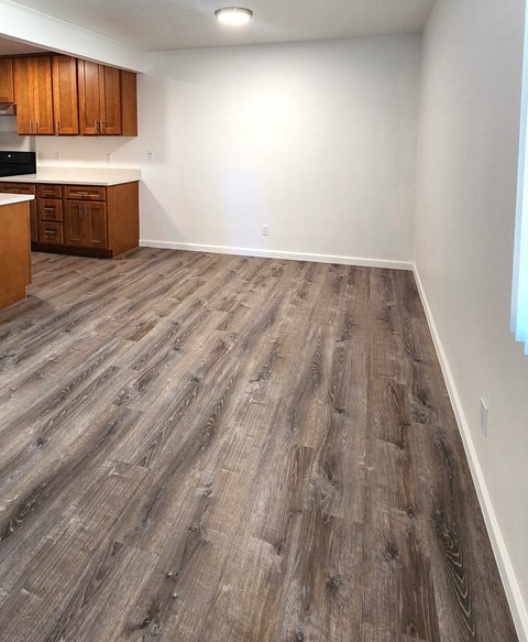 A kitchen with wooden cabinets and a wooden floor.