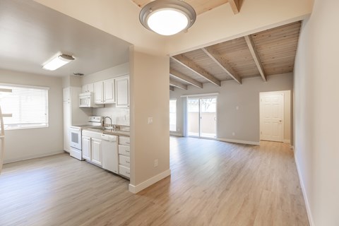 A kitchen with white cabinets and a wooden ceiling.