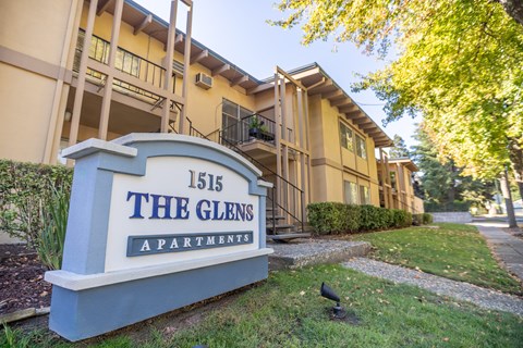 A sign for The Glens Apartments is in front of a building.