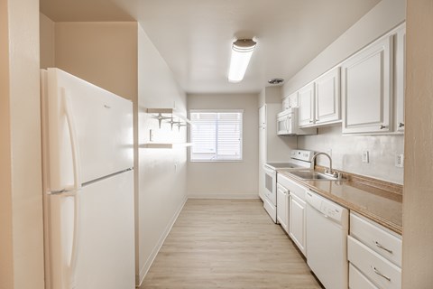 A kitchen with white appliances and cabinets.
