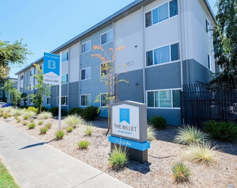 an apartment building with a blue and white parking sign in front