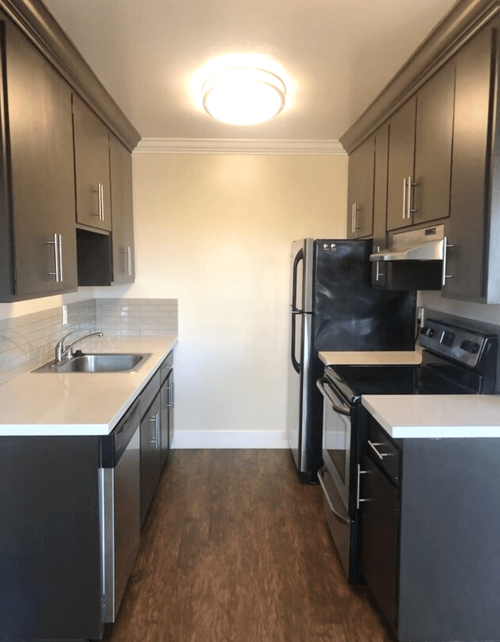 A kitchen with black cabinets and stainless steel appliances.