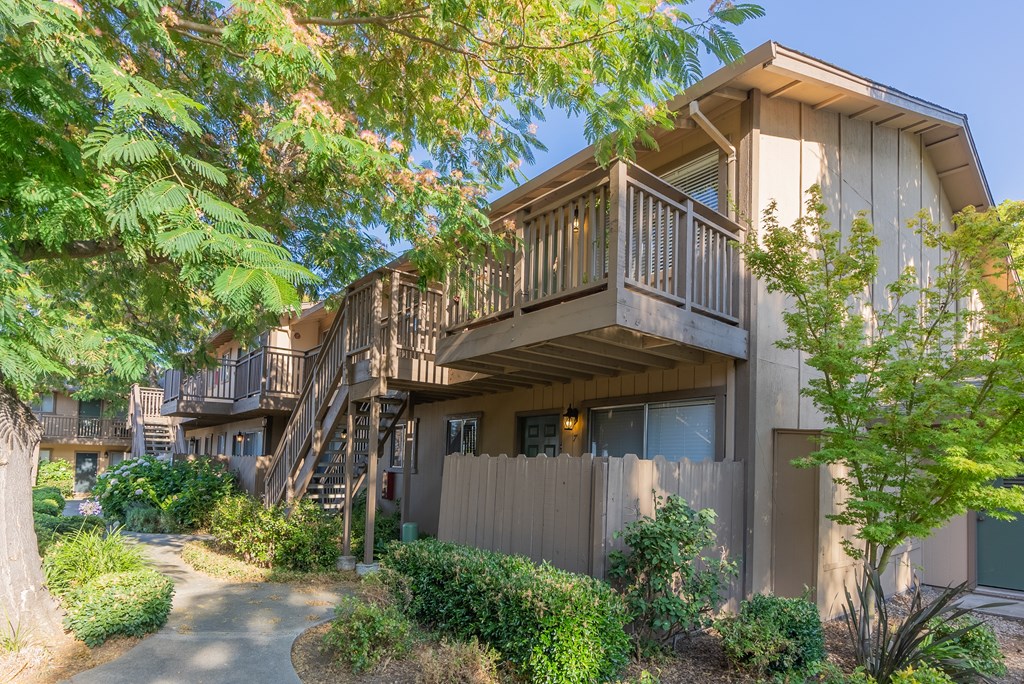 the exterior of a home with a balcony and a pathway