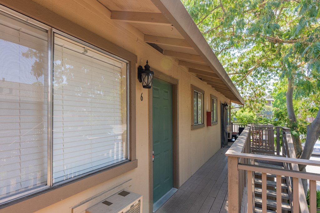 the front porch of a house with a green door