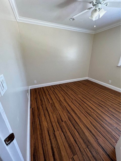 a room with a wooden floor and a ceiling fan