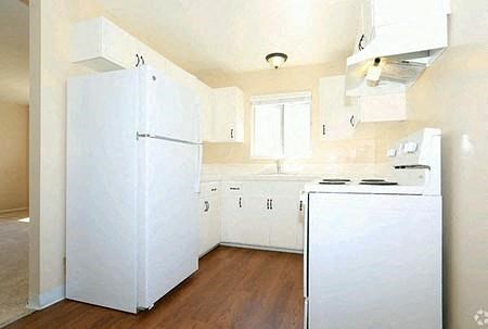 a white kitchen with a refrigerator and a stove