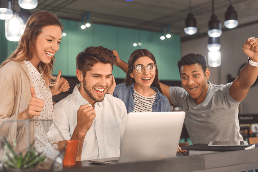 a group of people sitting around a laptop computer