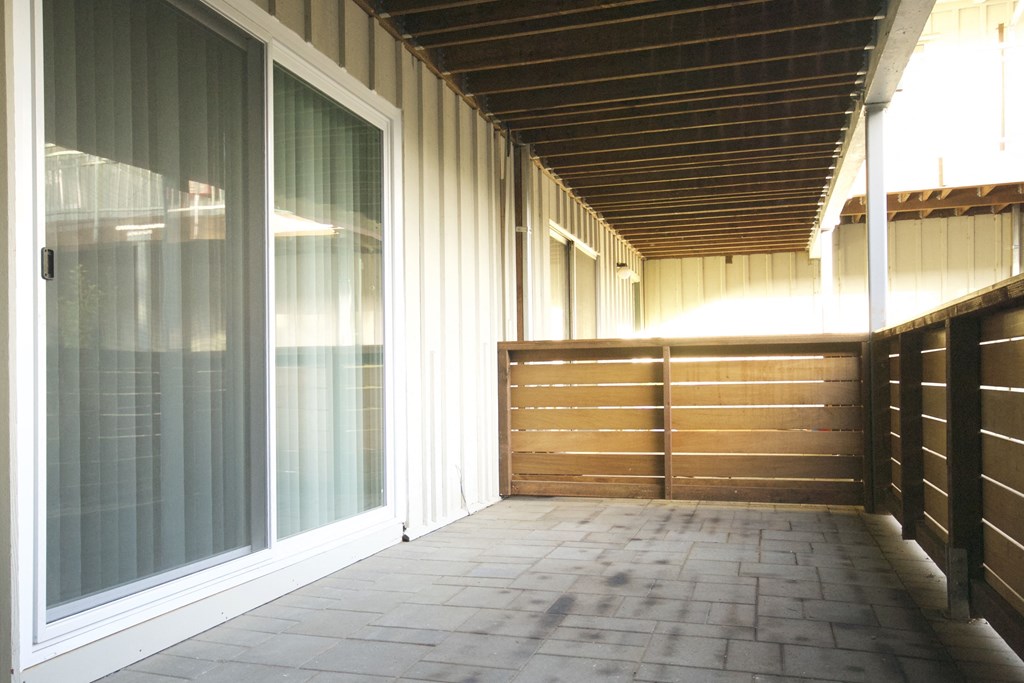 a view of the front porch of a house with a wood roof and a large glass door