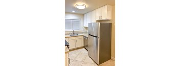 a kitchen with white cabinets and a stainless steel refrigerator