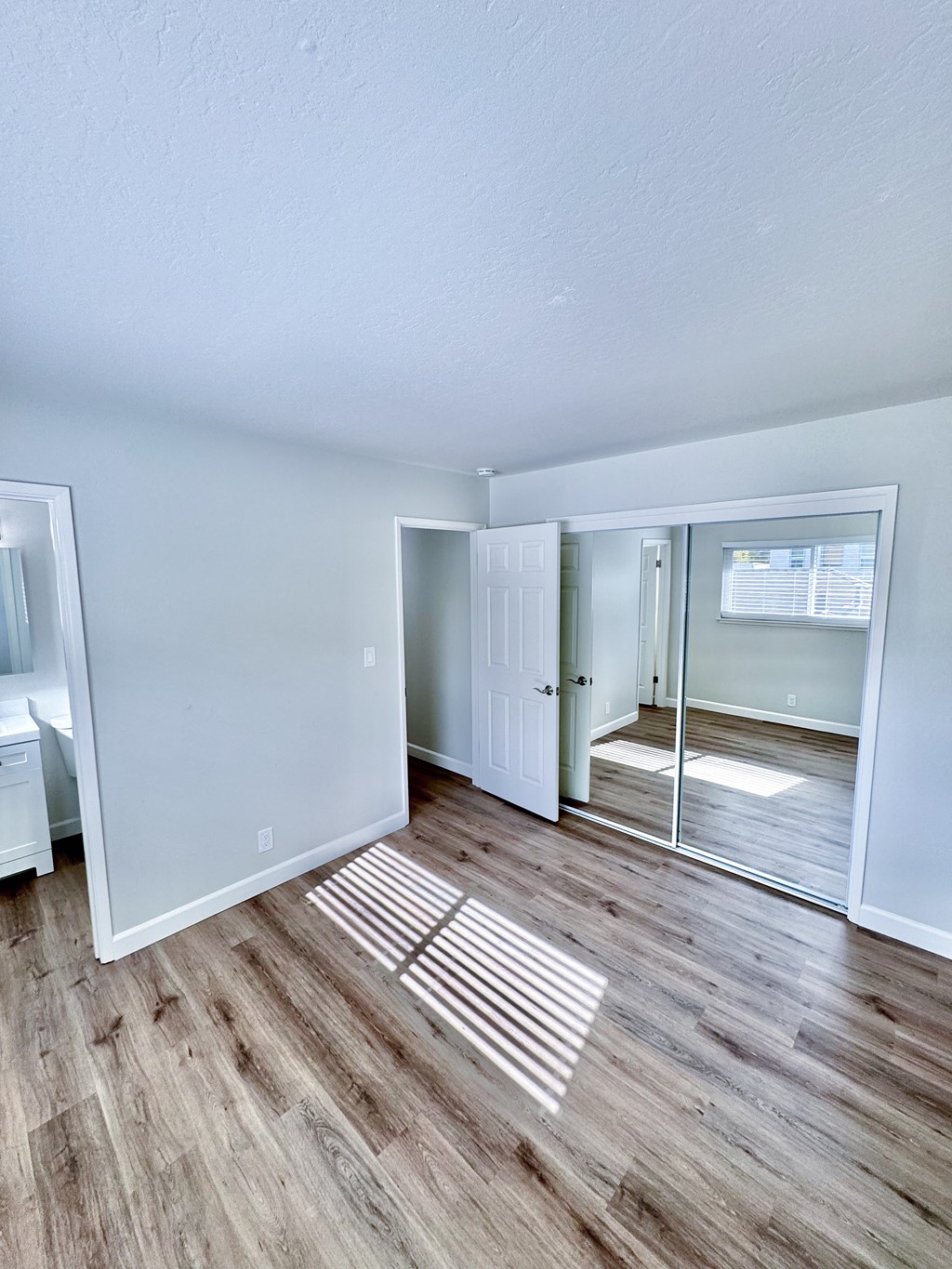 a living room with a hard wood floor and a sliding glass door