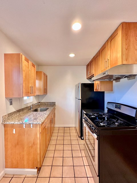 a kitchen with wooden cabinets and a stove and refrigerator