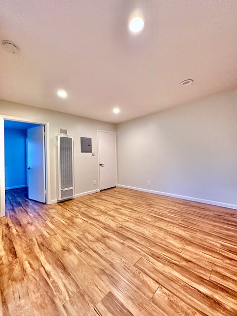 the living room of an empty house with wood flooring