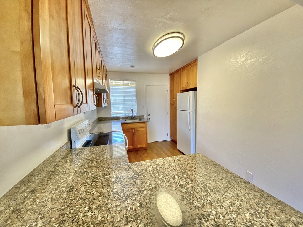 a kitchen with a granite counter top and a white refrigerator