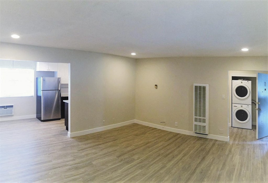 an empty living room with a washer and dryer