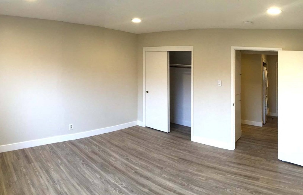 a living room with a hardwood floor and white walls
