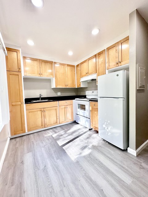 an empty kitchen with wooden cabinets and stainless steel appliances