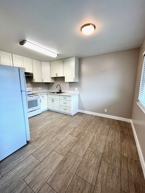 A kitchen with a blue refrigerator and white cabinets.