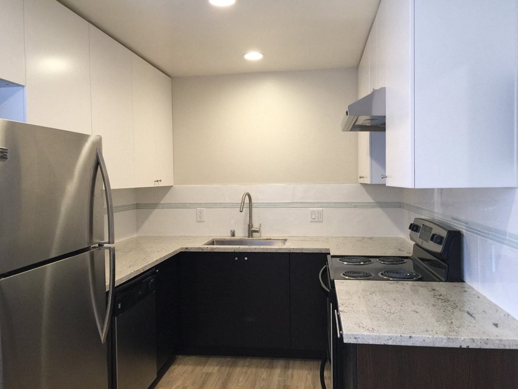 a kitchen with white cabinets and black appliances