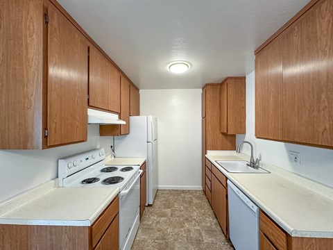 A kitchen with white appliances and wooden cabinets.