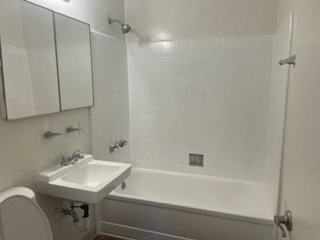 a white bathroom with a sink and a bath tub