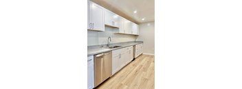 A kitchen with white cabinets and a stainless steel dishwasher.