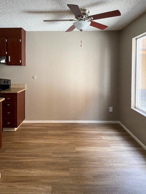 a living room with a ceiling fan and a wooden floor