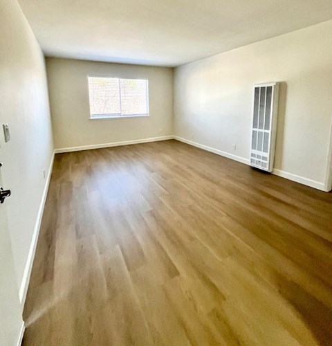 A room with wooden flooring and a window.