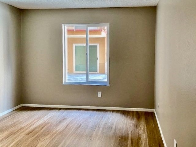 a empty room with a window and wooden floors