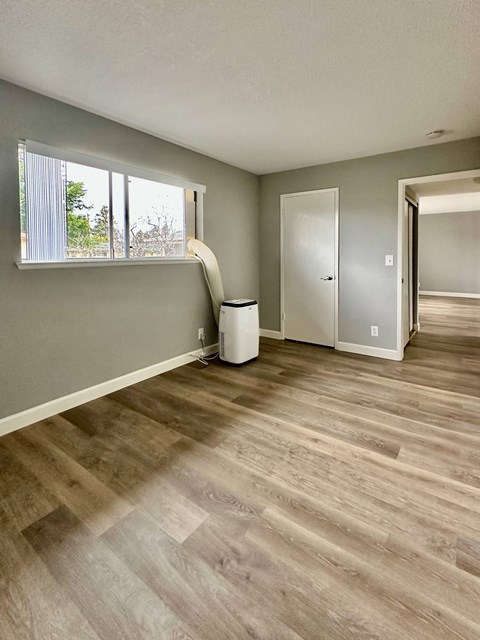 an empty living room with hardwood floors and a staircase