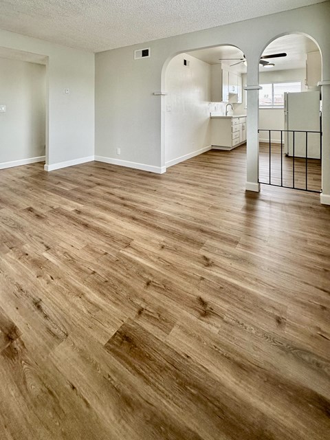 an empty living room with a hard wood floor