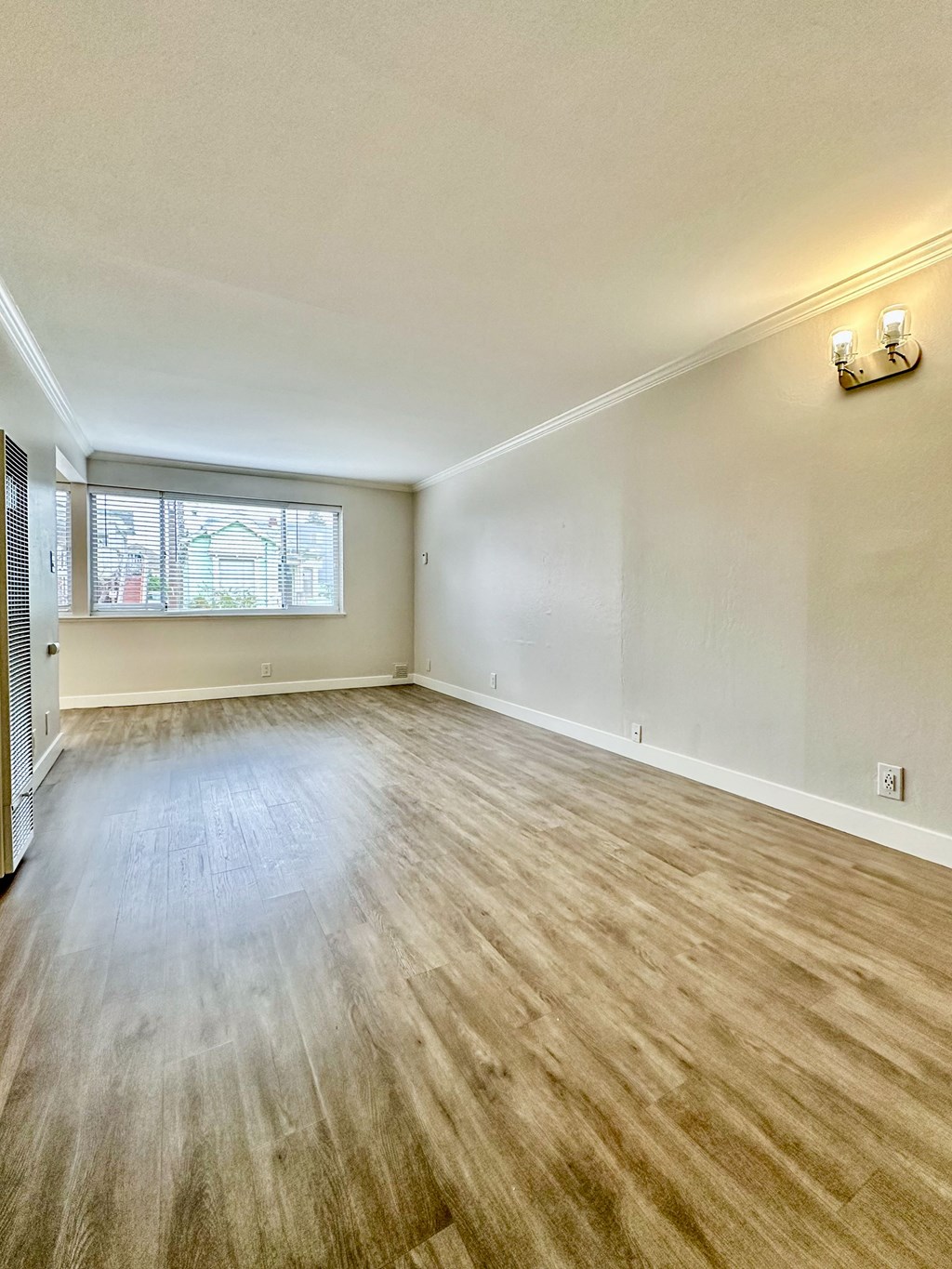 the living room and dining room of an empty home with wood flooring at The Chase Apartment Homes, Oakland, CA 94606
