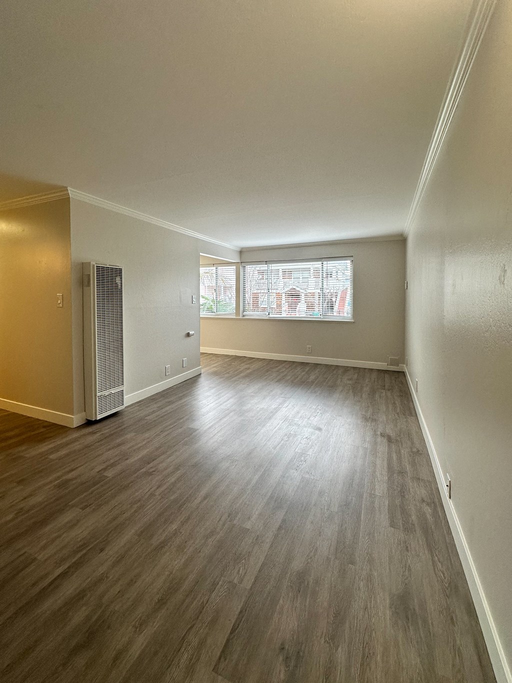 an empty living room with wood flooring and a window at The Chase Apartment Homes, California, 94606