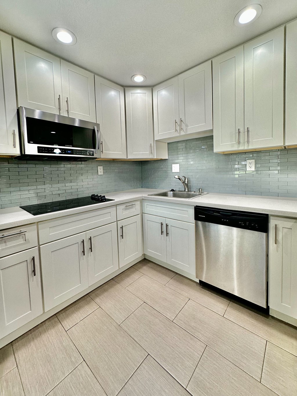 a kitchen with white cabinets and stainless steel appliances