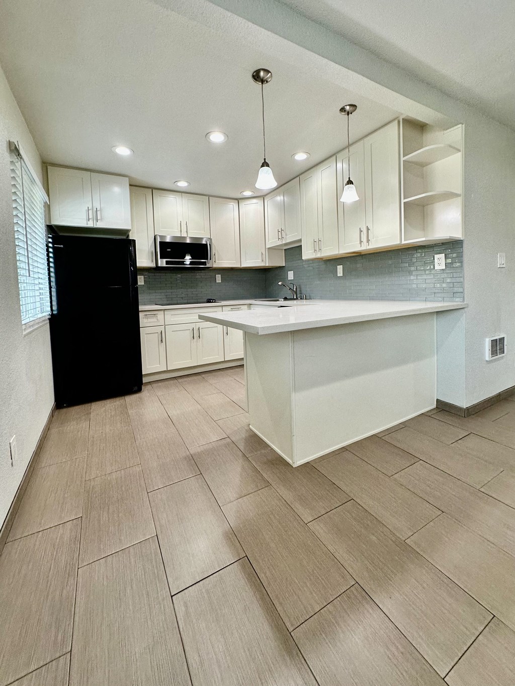 a large kitchen with white cabinets and a white counter top