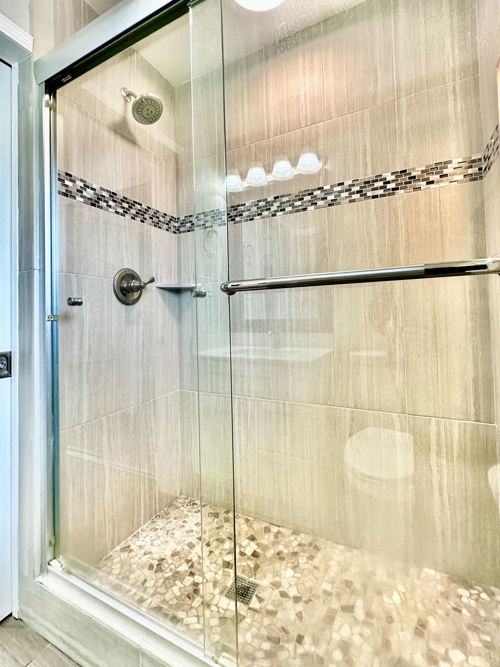 a large shower with a glass door in a bathroom