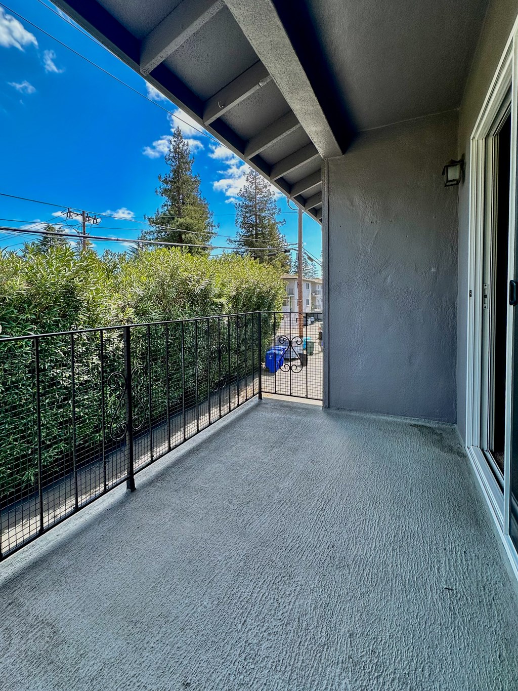 the balcony of a condo with a view of the yard and trees
