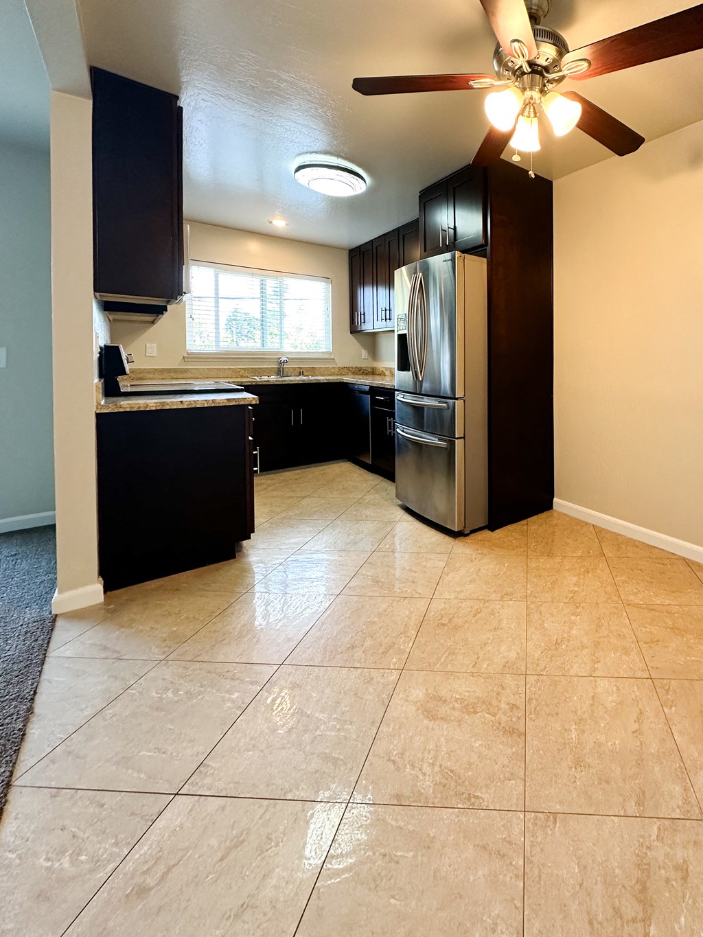 a kitchen with stainless steel appliances and a ceiling fan