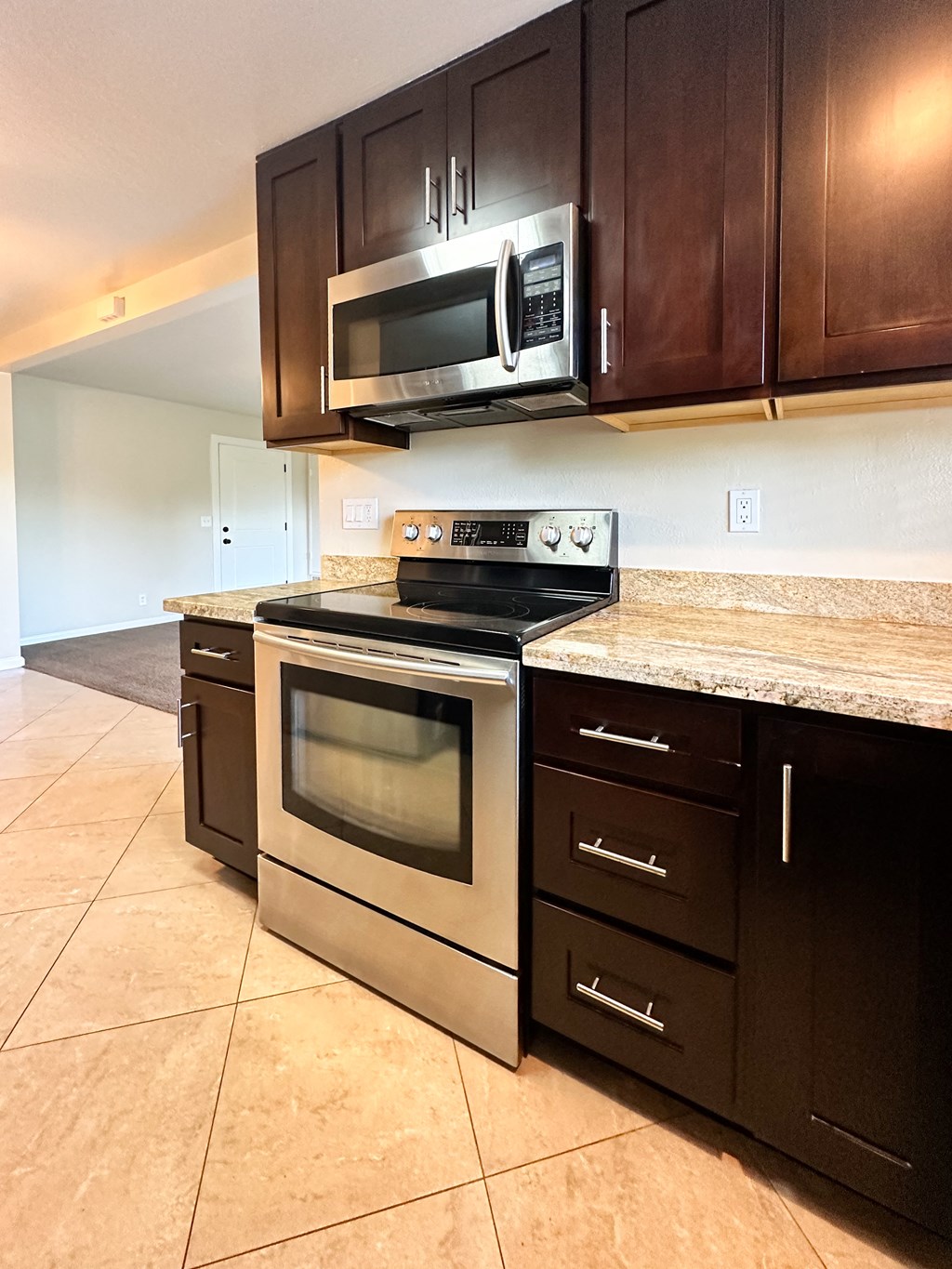the kitchen has stainless steel appliances and a granite counter top