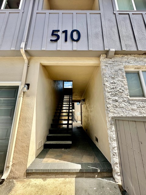 the front of a building with stairs and a number