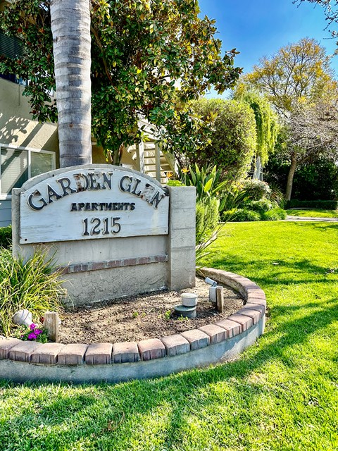 a sign apartments in front of a tree