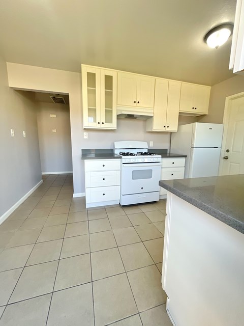 A kitchen with white cabinets and appliances.